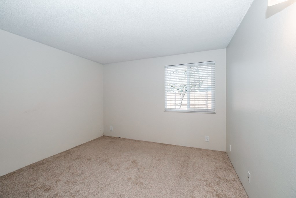 a bedroom with white walls and carpet