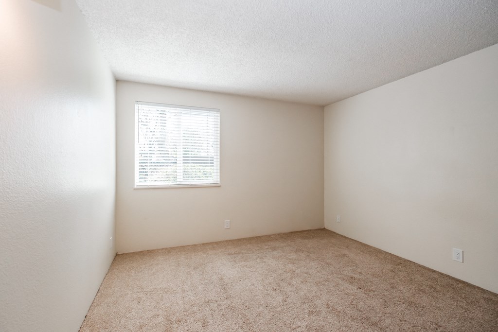 an empty bedroom with a window