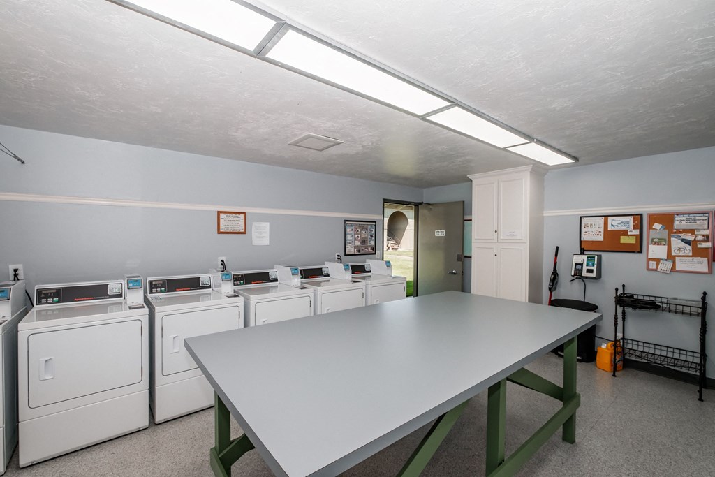 a laundry room with a table and washers and dryers