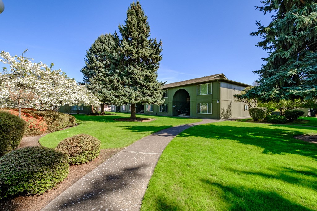 a home with a green exterior and manicured lawns