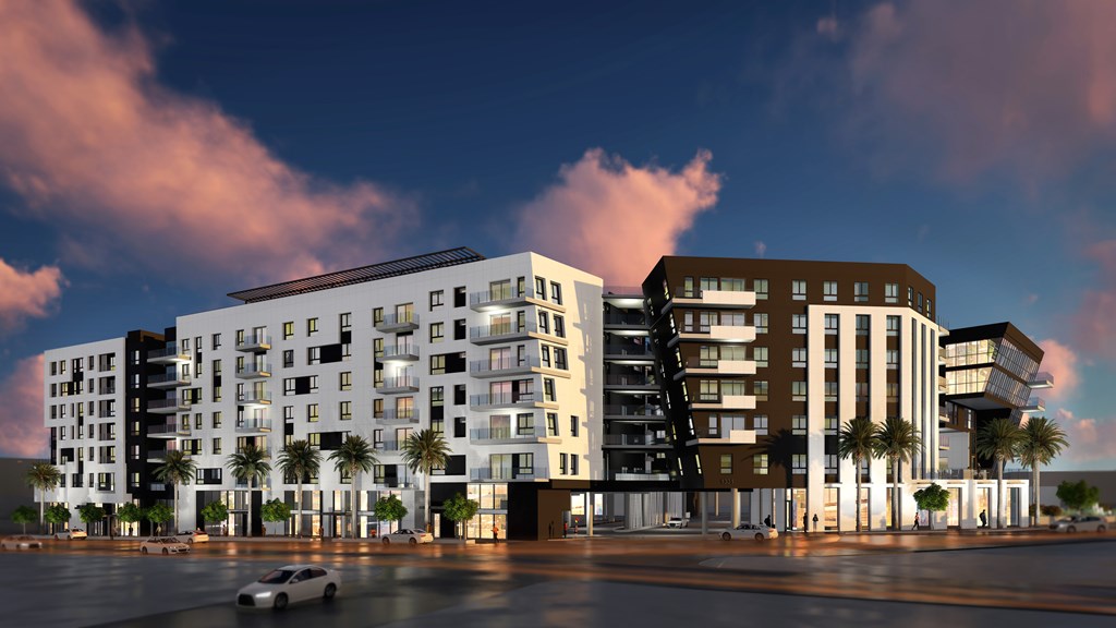 A modern apartment complex with a car parked in front.