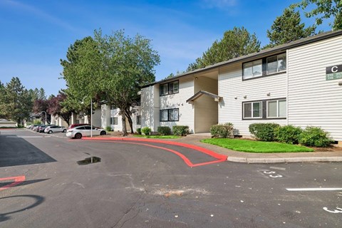 A parking lot in front of a building with a red line painted on the pavement.