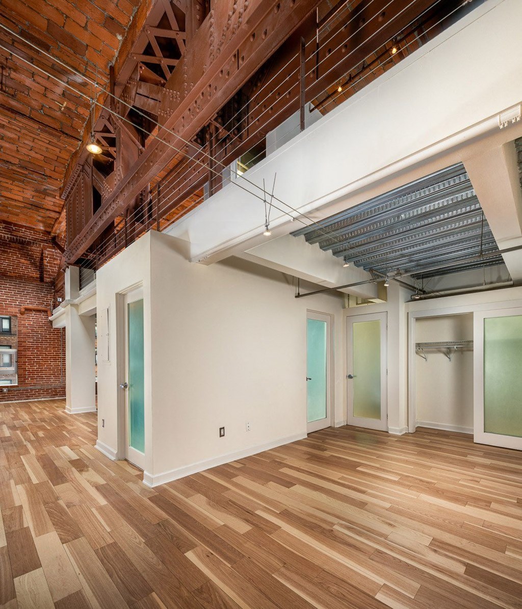 a large room with hardwood floors and exposed brick walls