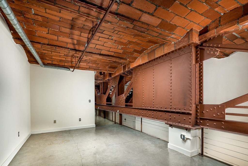 a large room with exposed brick ceilings and a white wall