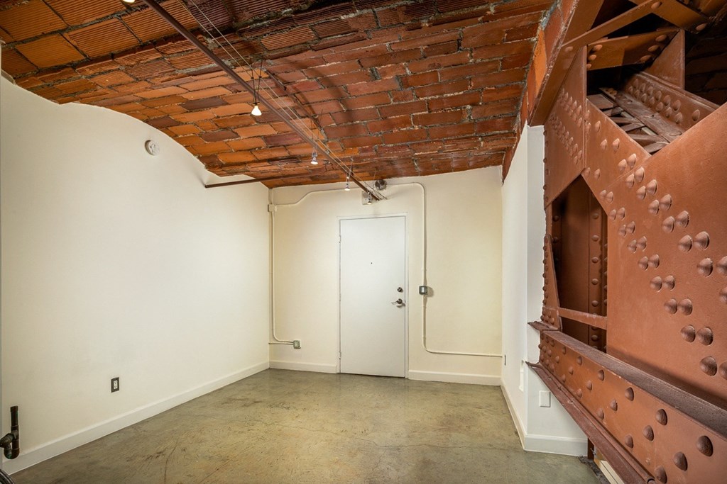 an empty room with a brick ceiling and white walls