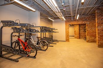 A room with a brick wall and a bike rack.