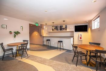 A room with a bar and seating area.