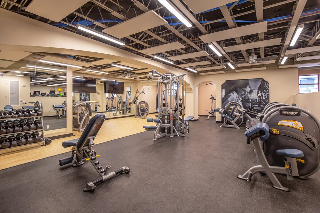 A gym with a variety of equipment including weights and machines. at The Benedictine, Tucson, 85716