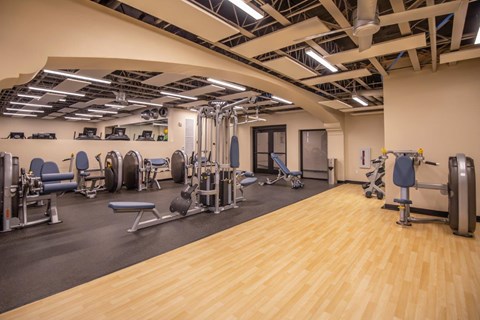 A gym with a variety of equipment including weights and machines.