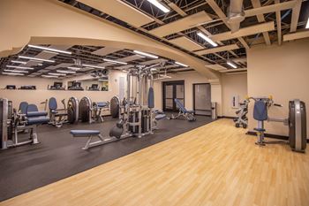 A gym with a variety of equipment including weights and machines.