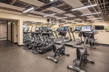 A gym with treadmills and elliptical machines.