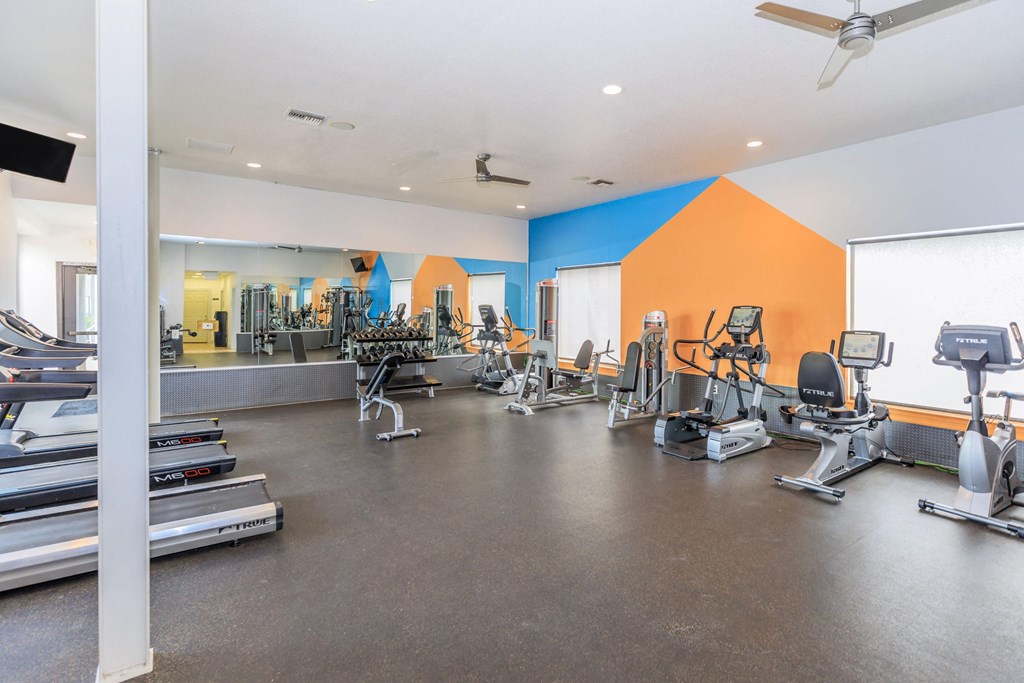 A gym with treadmills, weights, and exercise machines.
