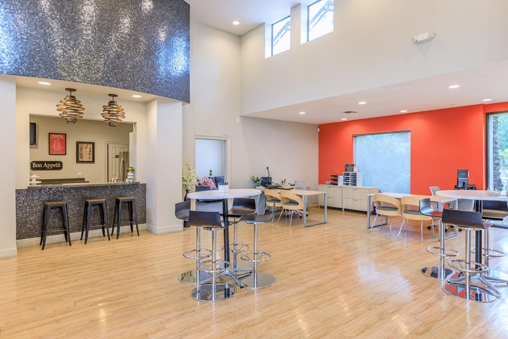 A modern kitchen with a bar area and a dining table.