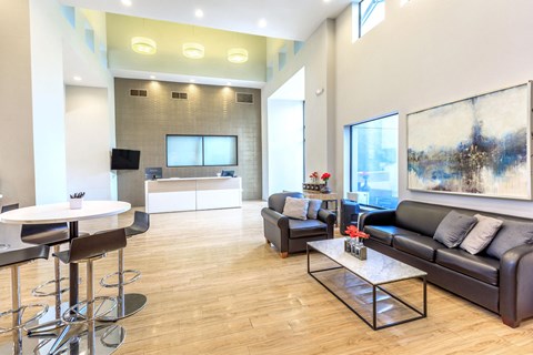 A modern living room with a black leather couch and a white coffee table.
