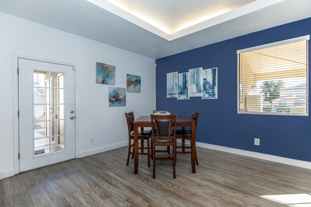A dining room with a table and chairs.
