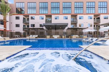 A large swimming pool in front of a multi-story building.