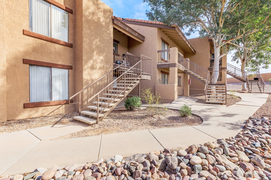 A building with a brown facade and a stone wall in front.