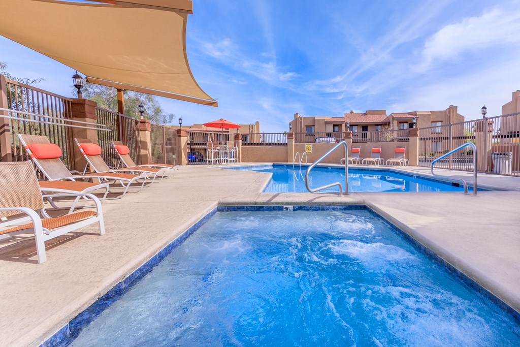 A pool with a slide and sun loungers.