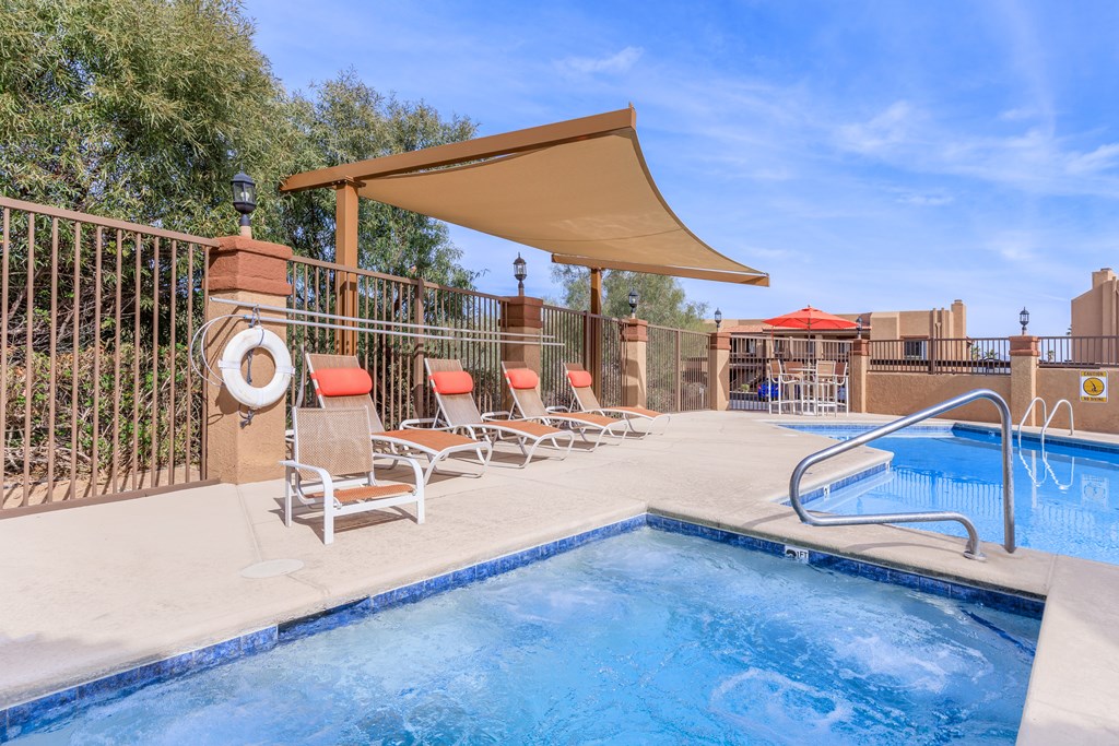 A pool with a sun lounger and a poolside table.