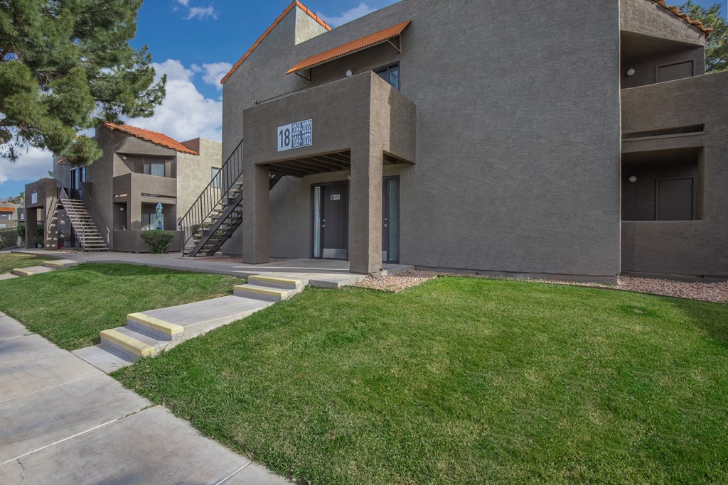 A modern building with a grey facade and a red roof.