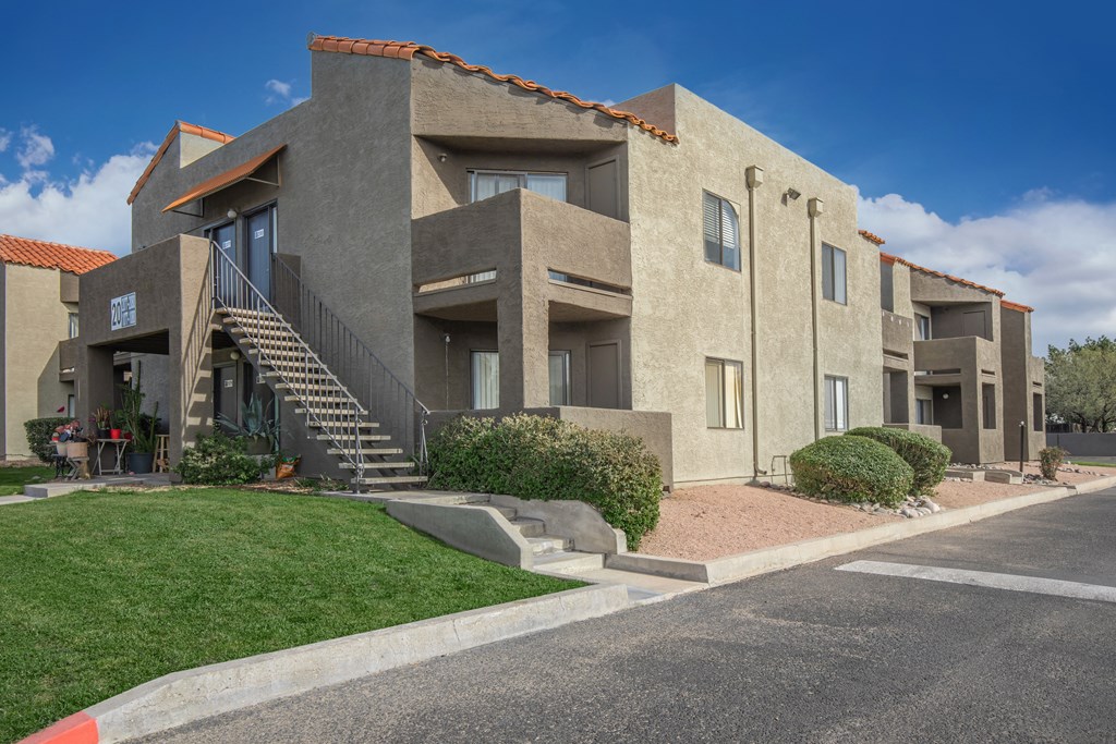 A modern building with a red tile roof and a staircase leading to the entrance.