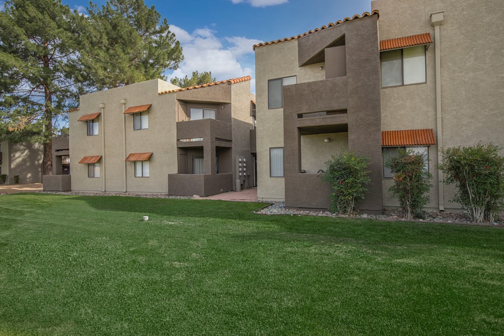 A row of houses with a green lawn in front.