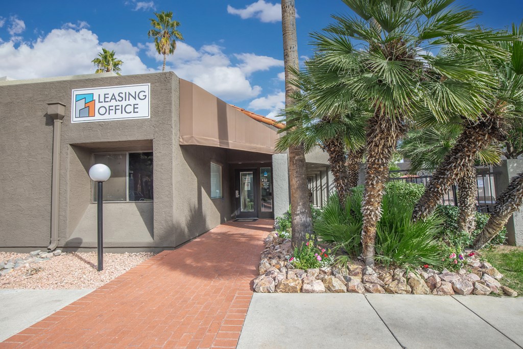 A leasing office building with a brick pathway leading to the entrance.