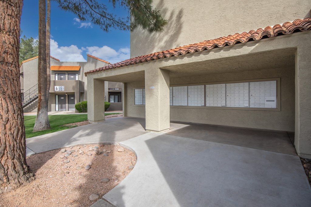 A building with a red tile roof and a tree in front of it.
