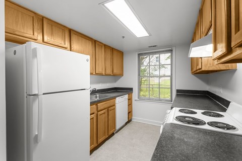 A white refrigerator is in a kitchen with wooden cabinets.
