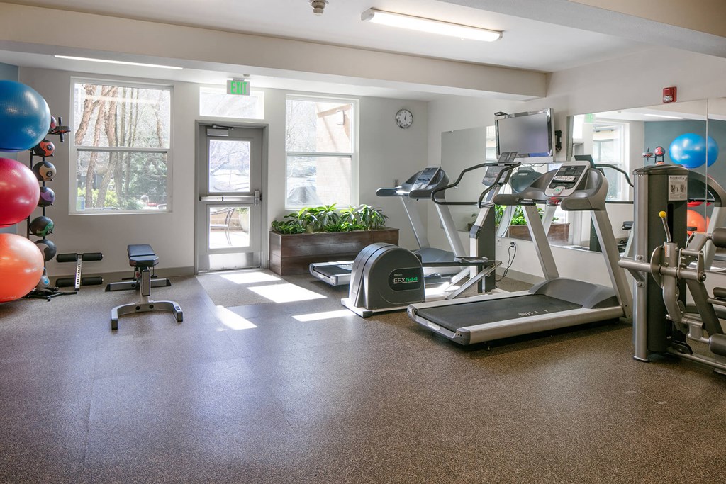 Collins Circle Apartments gym with cardio equipment and weights