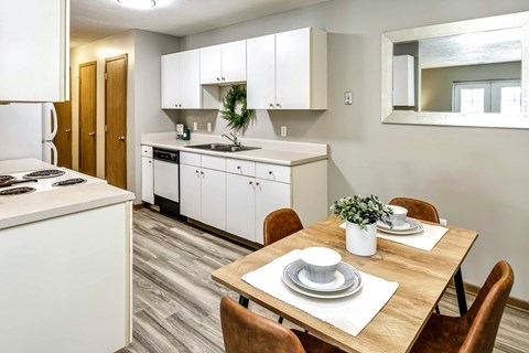 A kitchen with a dining table set for two.