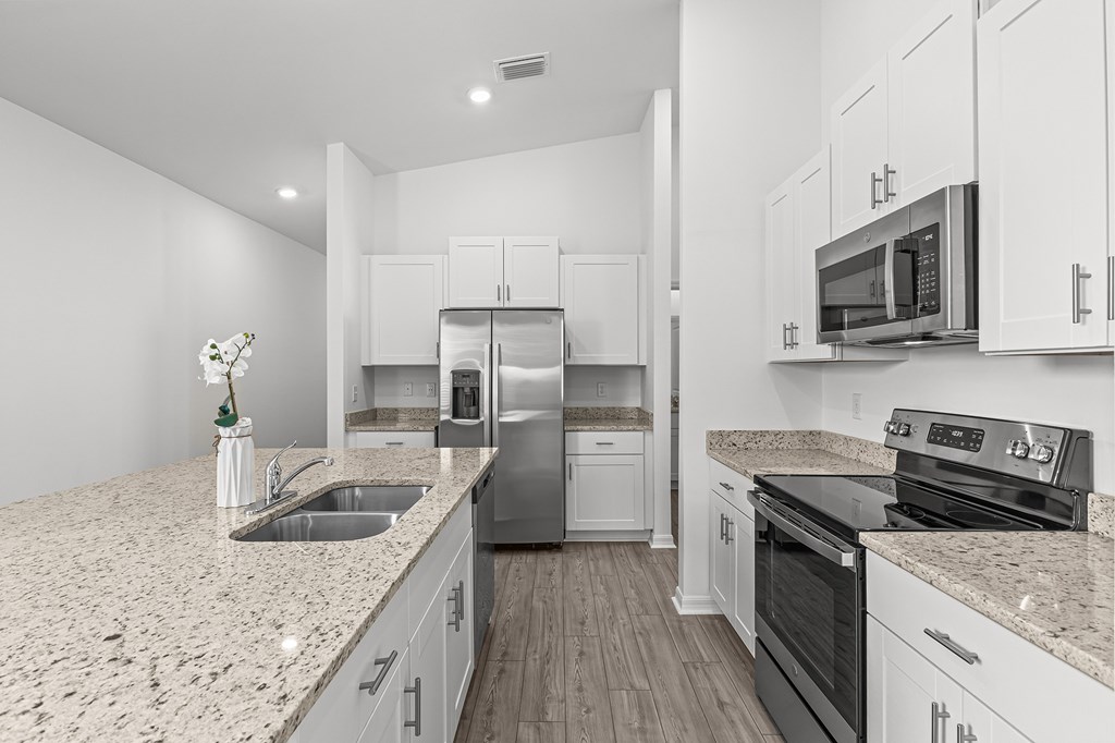 A kitchen with white cabinets and a granite countertop.