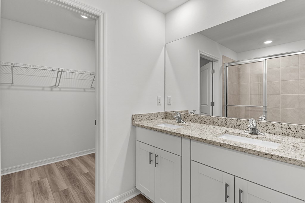 A bathroom with a vanity and a walk-in shower.