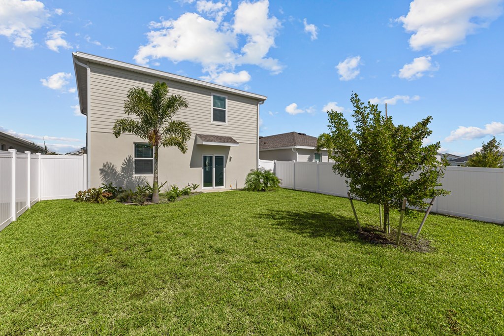A house with a green lawn and a tree in front.