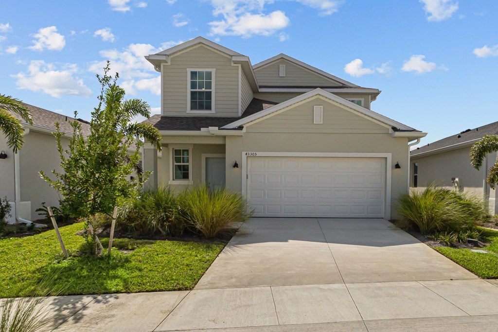 A house with a garage and a driveway in front.