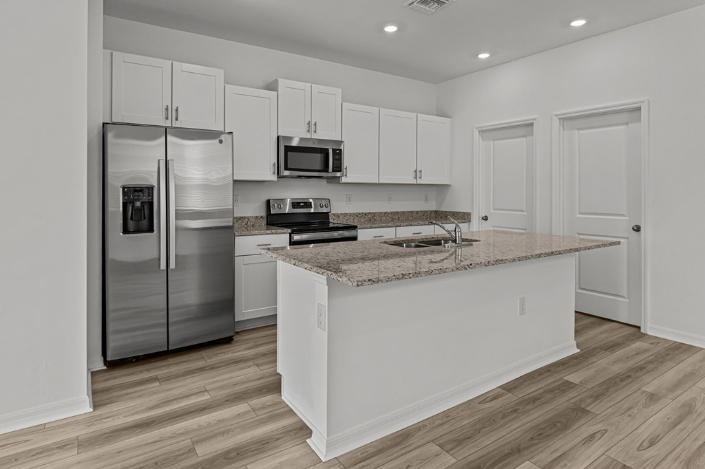 A kitchen with a granite countertop and stainless steel appliances.