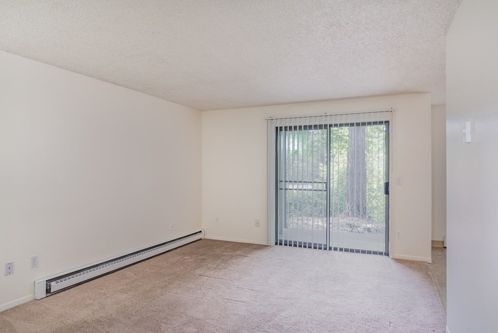 the spacious living room with sliding glass doors to the patio