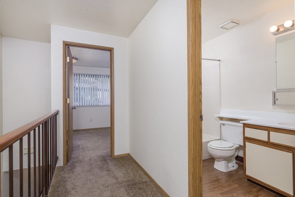 a renovated bathroom with a toilet and a sink in a room with a hall way