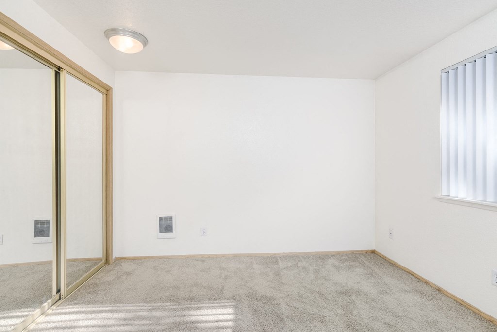 an empty room with a sliding glass door and a window