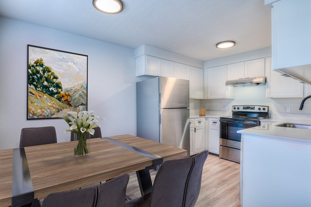 A kitchen with a dining table and chairs.