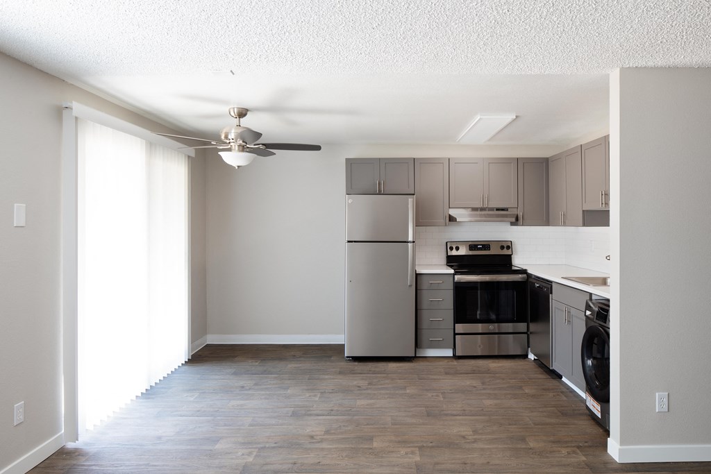 a kitchen with stainless steel appliances and a ceiling fan
