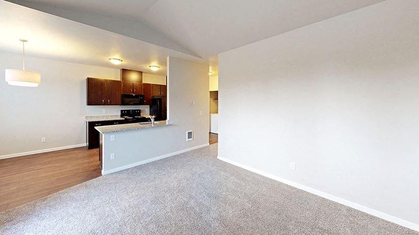 an empty room with a kitchen and a living room