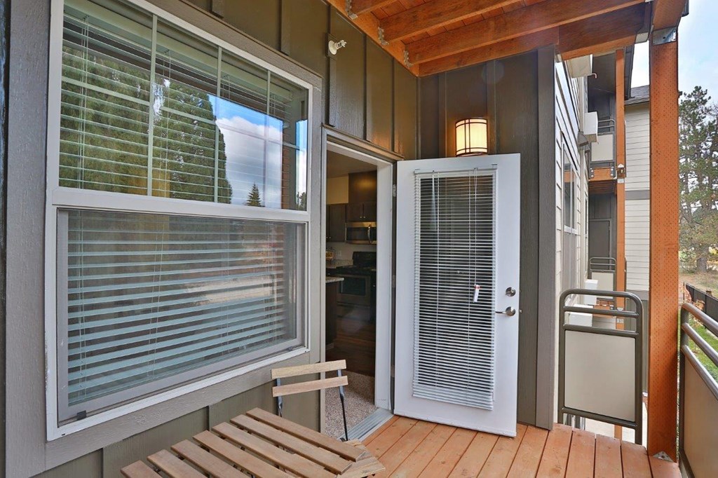 a front porch with a white door and a wooden bench