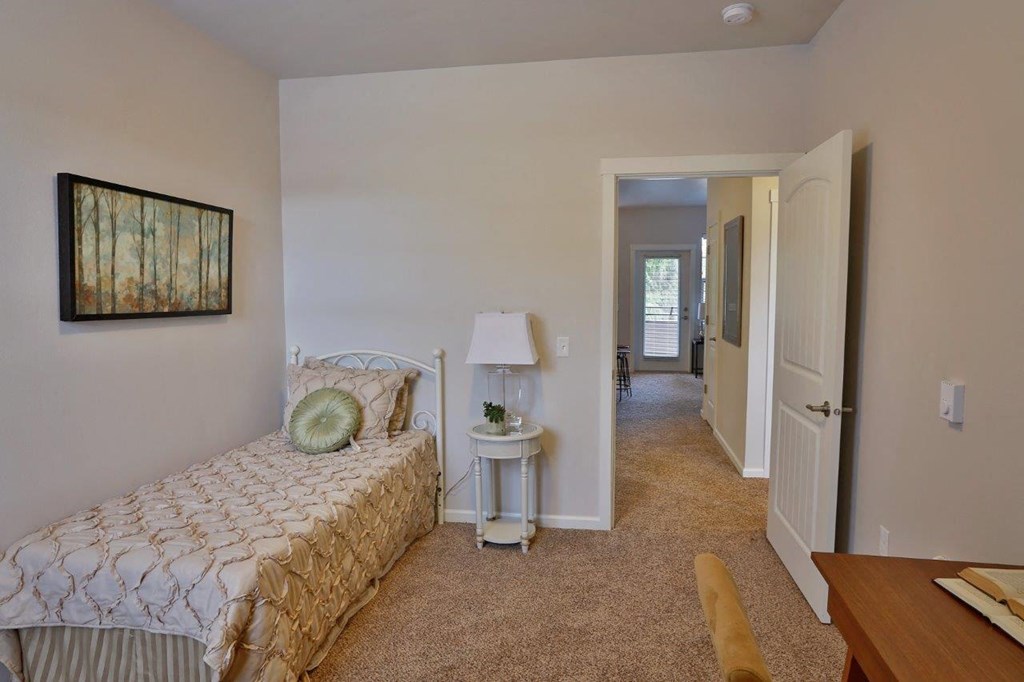 a bedroom with a bed and a hallway with a door