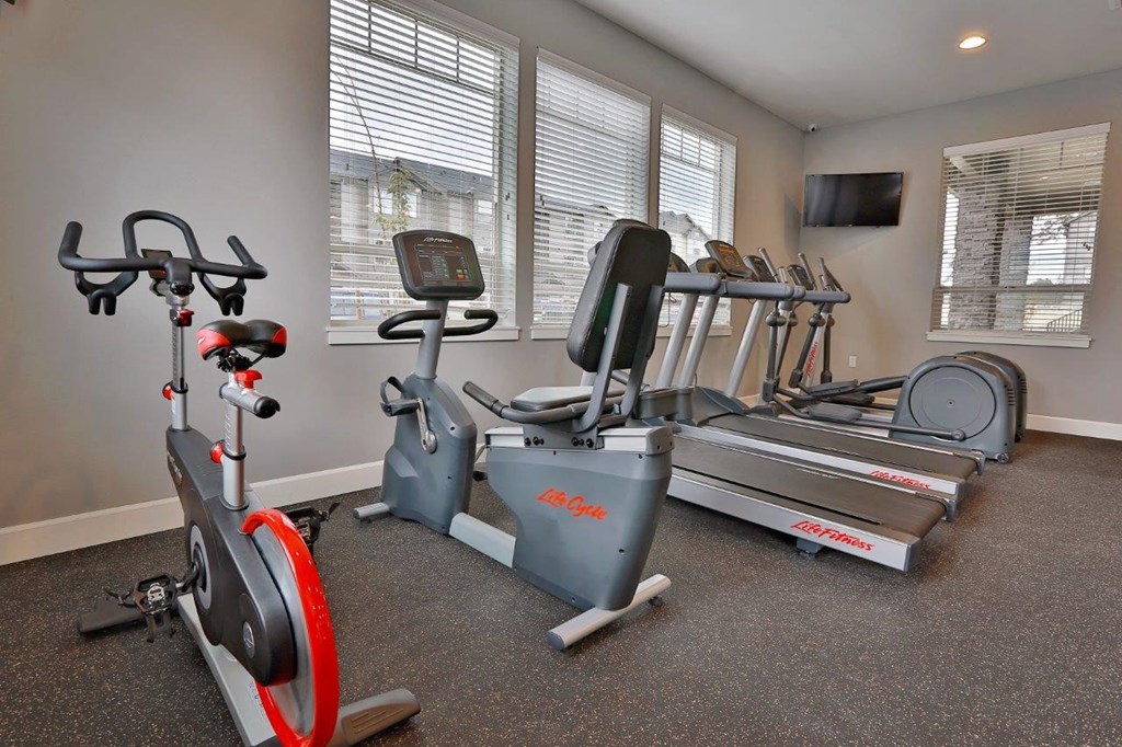 a home gym with exercise equipment and windows