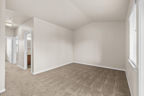 Spacious bedroom with vaulted ceiling and carpeting at Fruitland Meadow Apartments, Salem, Oregon