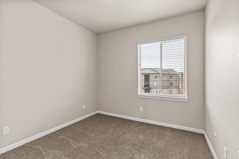 Empty carpeted bedroom with window and blinds at Fruitland Meadow Apartments, Salem, OR 97317