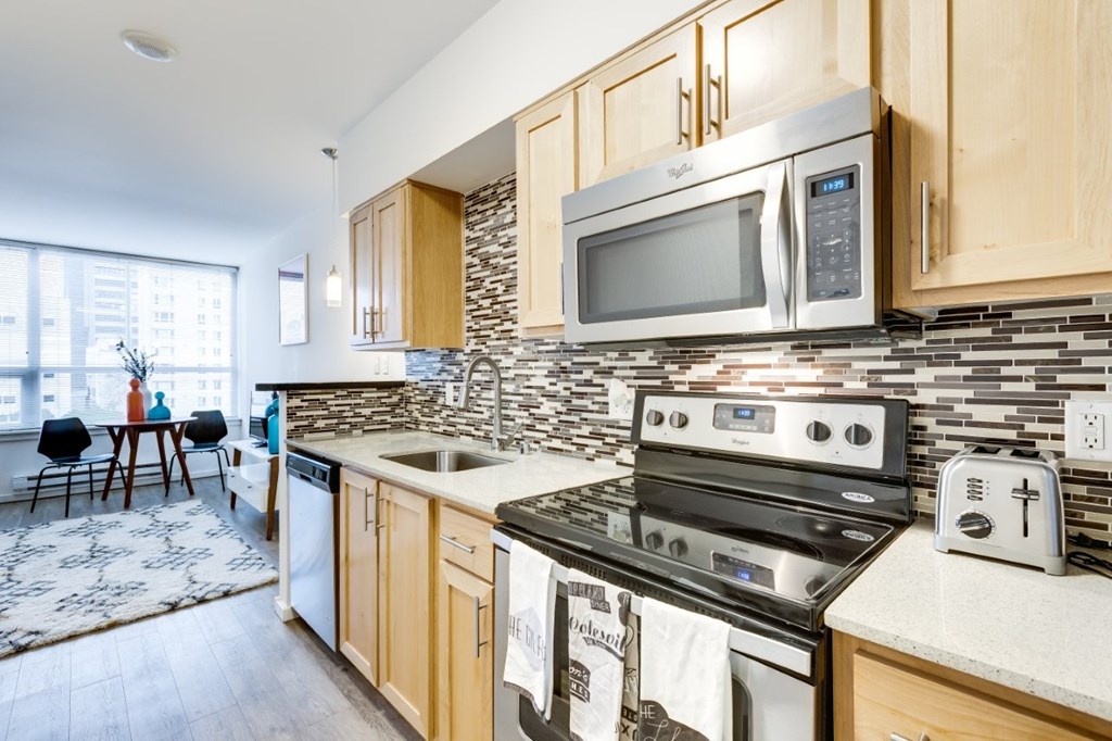 A kitchen with a stove, microwave, and oven.