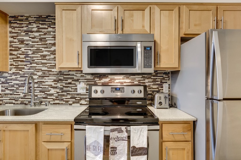 A kitchen with a stove, oven, microwave, and refrigerator.