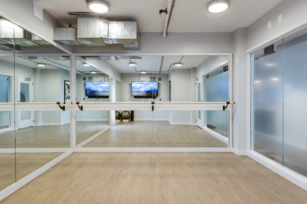 A spacious room with glass walls and wooden flooring.